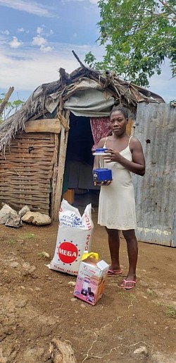 Noeldina receiving Rice Oil and a solar Lantern